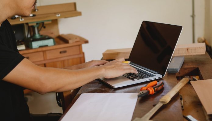 crop craftsman working on laptop in workplace